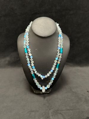 a necklace with blue and white beads on a mannequin