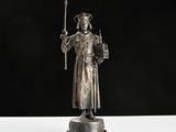 a silver statue of a man holding a sword and a shield