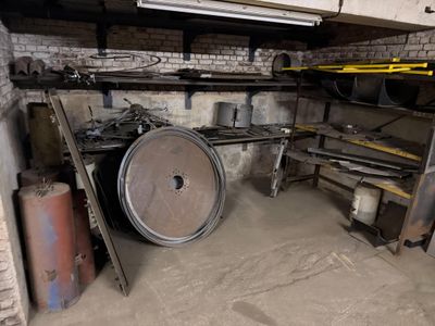 a large metal barrel sitting in a dirty room