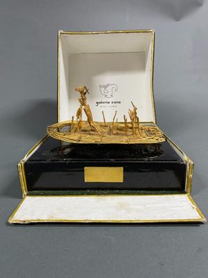 a gold and black box with a boat inside of it