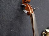 a violin that is sitting on the wall next to a vase