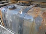 a rusty suitcase sitting on the ground next to a train
