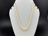 un collier de perles dorées sur un mannequin d'exposition