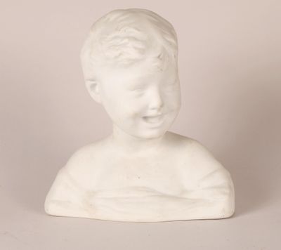une statue blanche représentant un jeune garçon au sourire radieux