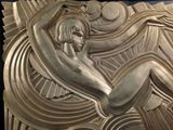 a sculpture of a woman sitting on top of a wall