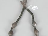 an image of a necklace with a silver bead and a silver bell