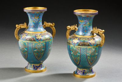 pair of blue and gold vases sitting on a gray surface
