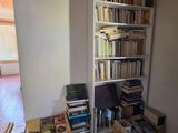 une bibliothèque remplie de livres dans un coin de la pièce