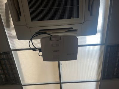 an air conditioner sitting on top of a tiled floor next to a window