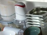 a picture of a cluttered kitchen sink with dishes and cups