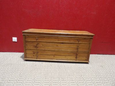 une petite commode en bois posée à même le sol