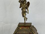 a clock with a statue of an angel on top of it