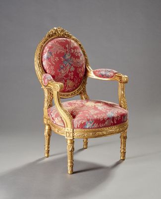une chaise ancienne avec une assise rembourrée rouge et des finitions dorées