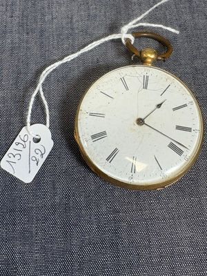 une montre de poche en or à laquelle est accrochée une étiquette sur le côté