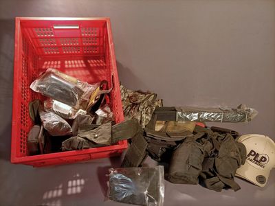 a red basket filled with assorted items sitting on a table