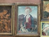 four framed paintings on the wall of a building