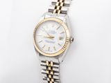 a lady ' s rolex watch on a white and gold bracelet
