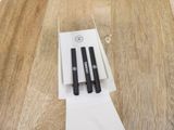 two pens sitting on top of a piece of paper on a table
