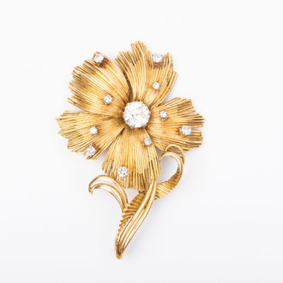 an image of a gold flower brooch with diamonds on it