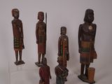 plusieurs figurines en bois de formes et de tailles variées posées sur une surface blanche
