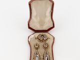 an open box with a pair of earrings in it on a white surface