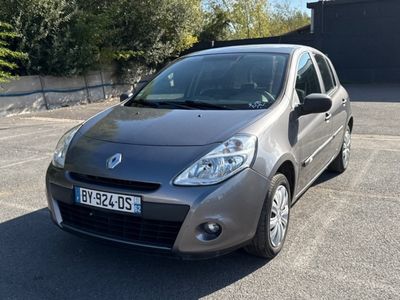 une voiture argentée garée sur un parking, avec des arbres en arrière-plan
