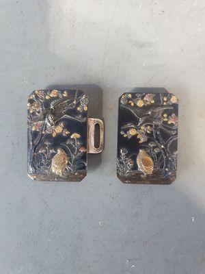 une paire d'étuis à cigarettes noirs et dorés ornés d'oiseaux et de fleurs