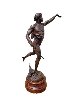 bronze statue of a man holding a sword on a wooden base