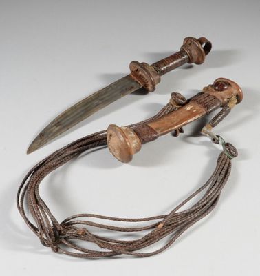 une paire de couteaux en bois et en métal, attachés par une corde, posés sur une surface blanche