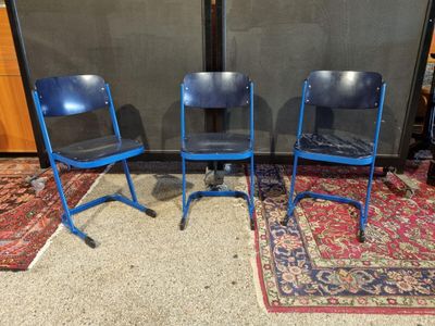 deux chaises bleues posées sur un tapis devant un mur