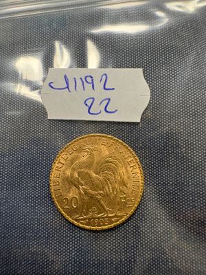 a gold coin with a label on it sitting on top of a blue cloth