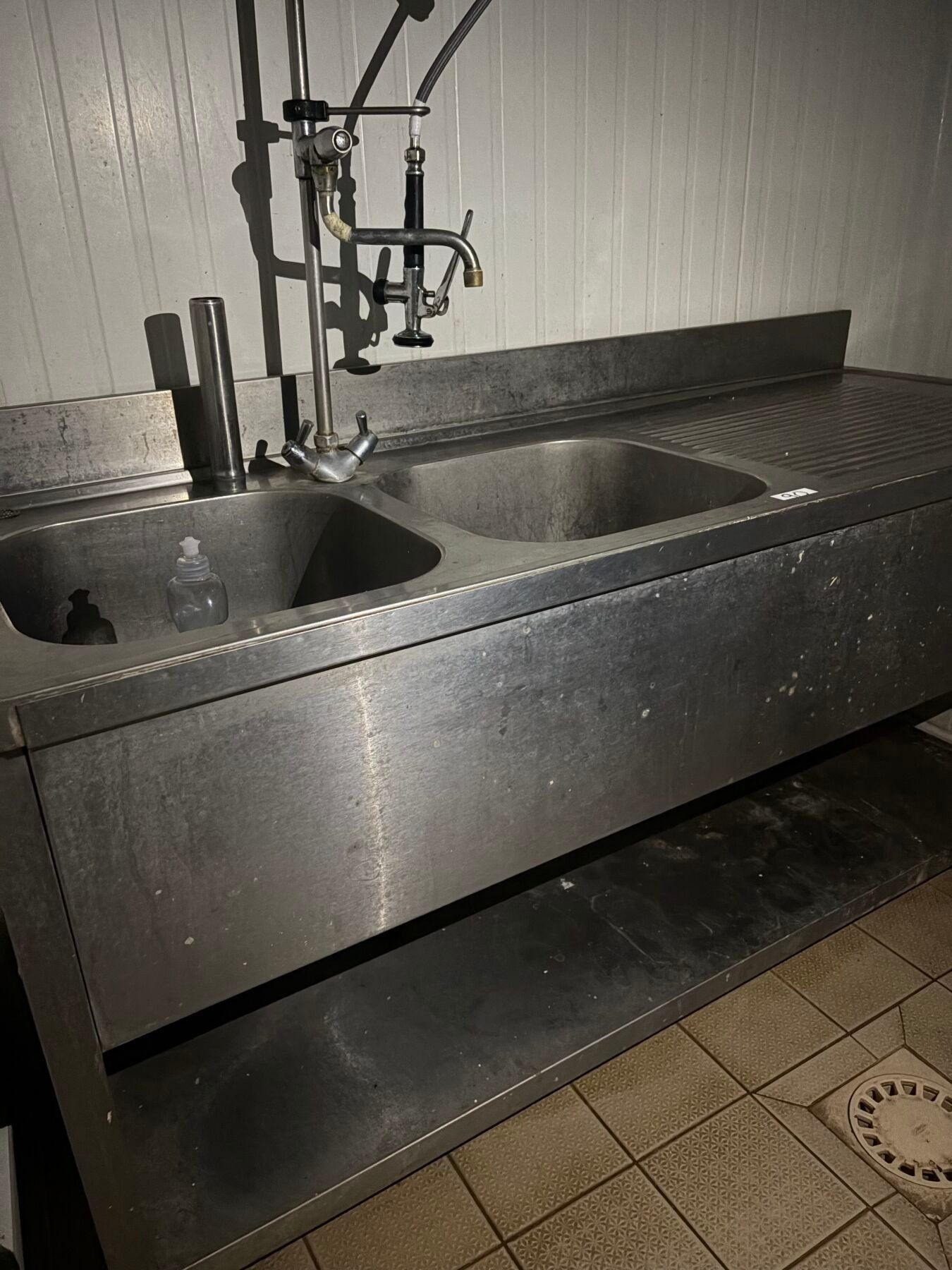 Une plonge inox deux bacs avec douchette.