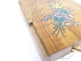 a small wooden box with a flower design on it