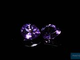 a pair of purple sapphires on a black background