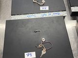 quatre ordinateurs portables posés sur une table en métal, avec des étiquettes dessus