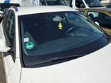 a white car with a yellow sticker on the windshield