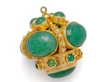 un gros plan d'une bague ornée de pierres vertes sur un fond blanc