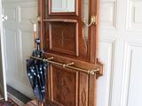 une horloge de parquet en bois avec un parapluie posé sur un tapis