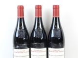 trois bouteilles de vin rouge sont alignées sur une surface blanche