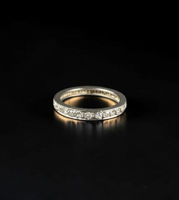 a white gold wedding ring with diamonds on a black background