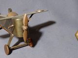 un petit avion miniature à côté d'un petit objet en or