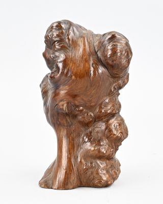 sculpture marron représentant un chien dont la tête repose sur une souche d'arbre