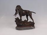 statue of a dog standing on a rock on a white surface