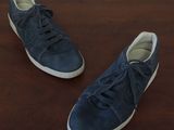 they are two pairs of blue sneakers on a wooden table