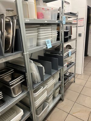 many shelves with pots and pans on them in the kitchen