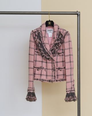 une veste rose suspendue à un portant devant un mur blanc