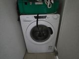 une machine à laver surmontée d'un panier