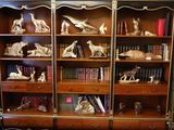 une bibliothèque sur laquelle sont posés de nombreux livres et des statues