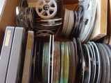 une boîte remplie de bobines de film posée sur une table