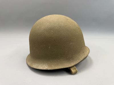 un vieux casque est posé sur une surface blanche